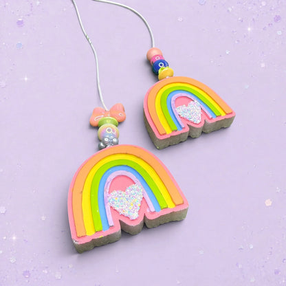 BeFreshie mini rainbow car freshies with Whirly Curlz clips and glittery heart accents on a purple background.